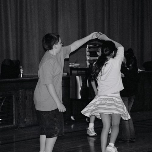 Swing dance school program - two boy twirls girl.