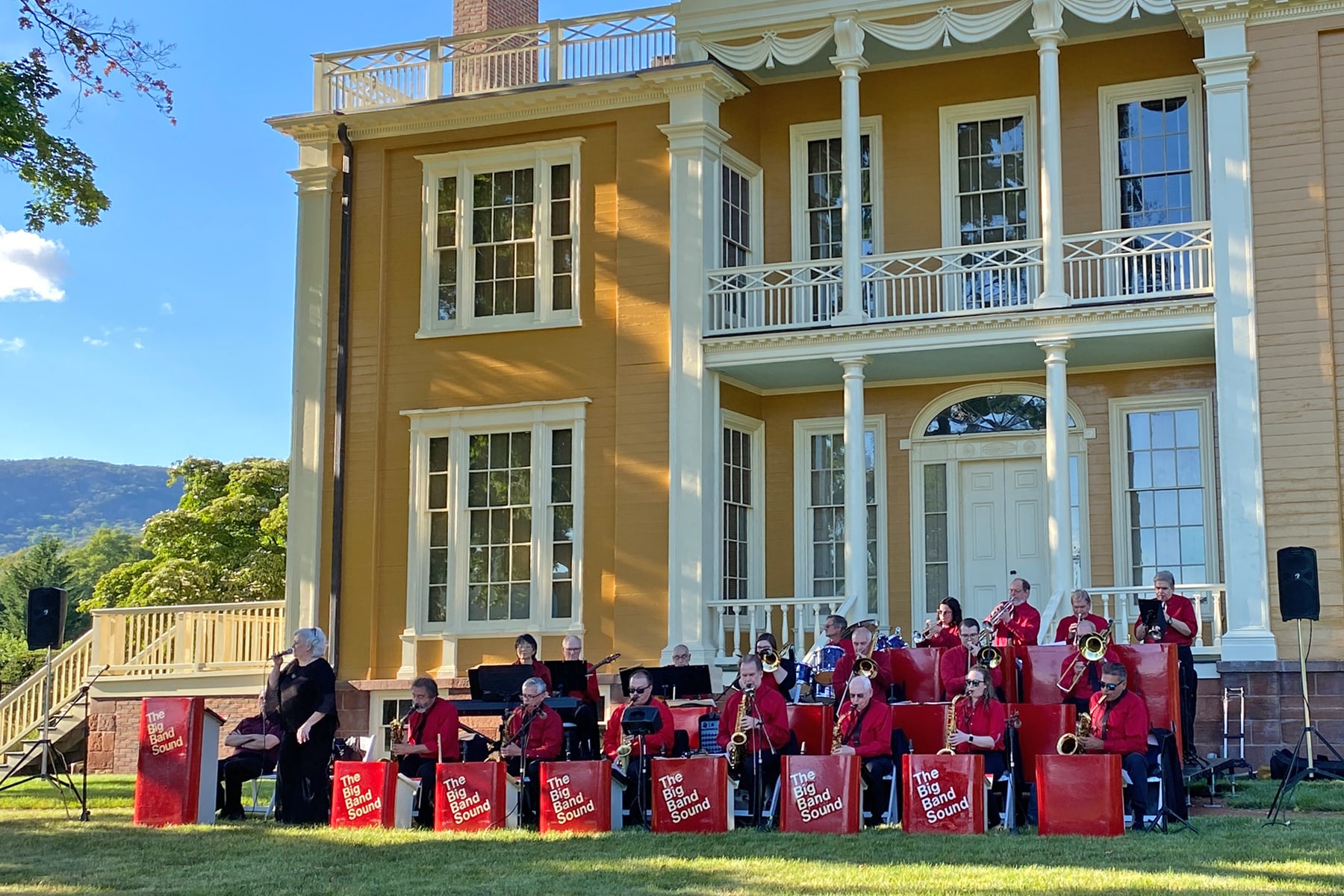 The band playing outside in front of a home.